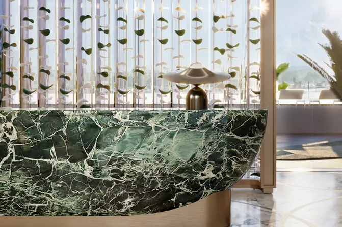 Green marble reception desk in front of a decorative glass screen